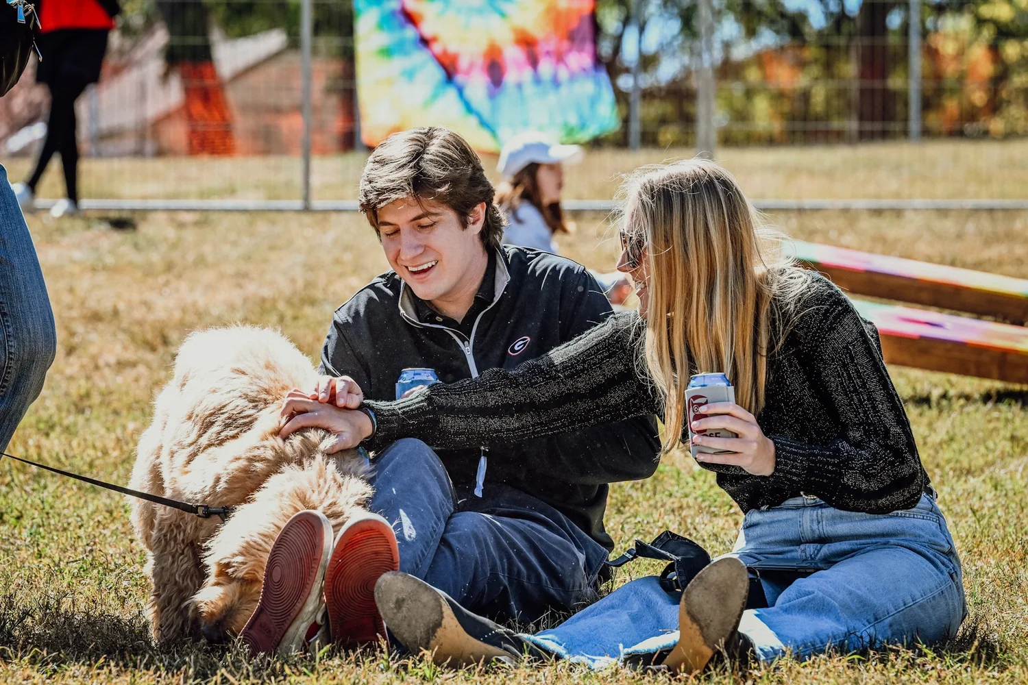 A couple and their doodle relaxing on the lawn at Touch of Brews 2022