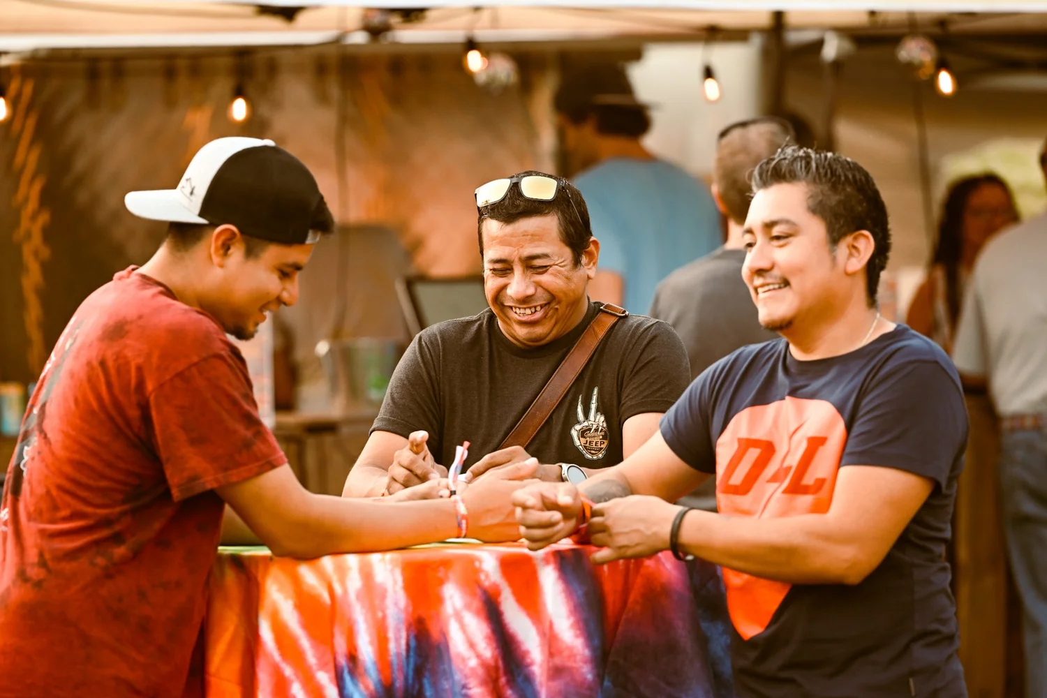Friends laughing at a Shakedown Street vendor table at Touch of Brews 2023