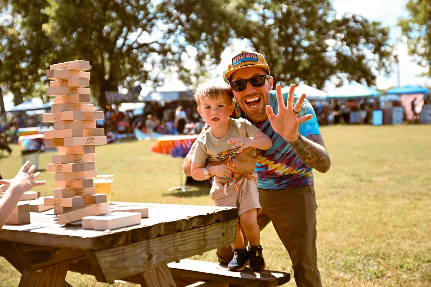 A face painted kid eating in a hammock chair at the Touch of Brews 2023 Kids Zone
